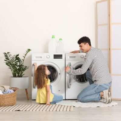 Young,Father,And,His,Daughter,Putting,Laundry,Into,Washing,Machine